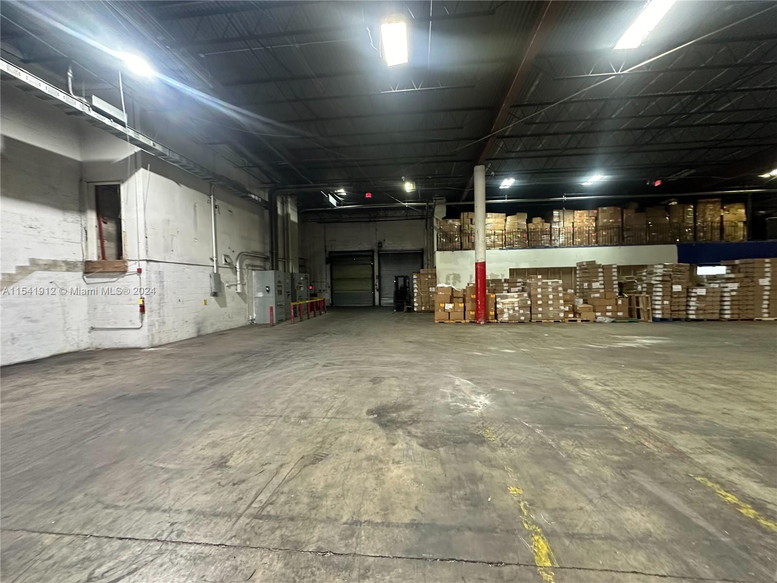 An industrial warehouse interior features concrete floors, high ceilings, and stacked cardboard boxes — 13449 NW 42nd Ave, Opa-Locka FL 33054, OPA-LOCKA, FL