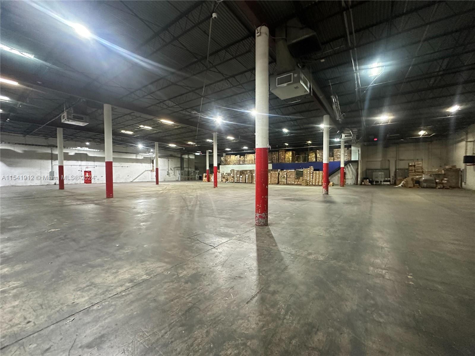 A large, open warehouse space features concrete floors and multiple red-and-white support columns — 13449 NW 42nd Ave, Opa-Locka FL 33054, OPA-LOCKA, FL