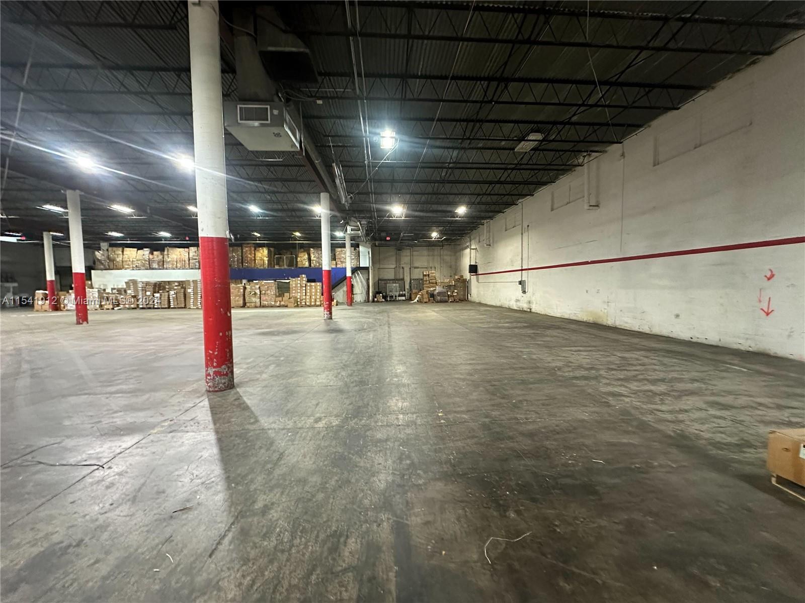 A large, open warehouse features concrete floors, exposed ceiling trusses, and red-painted support columns — 13449 NW 42nd Ave, Opa-Locka FL 33054, OPA-LOCKA, FL