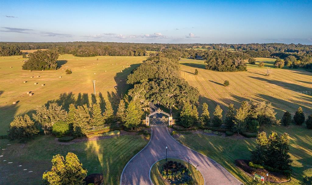 An aerial view of a gated entrance leading to a long driveway through a pasture — TBD SE 8TH AVENUE Lot 306, OCALA, FL