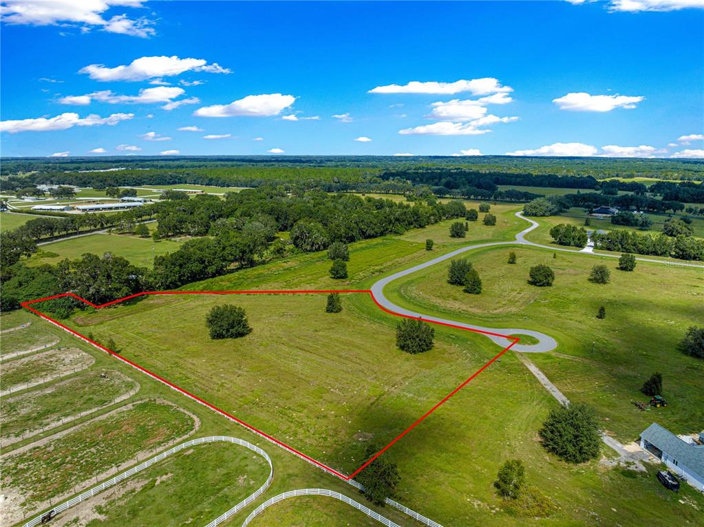 An aerial view shows a large, grassy vacant lot outlined in red with scattered trees — TBD SE 8TH AVENUE Lot 306, OCALA, FL