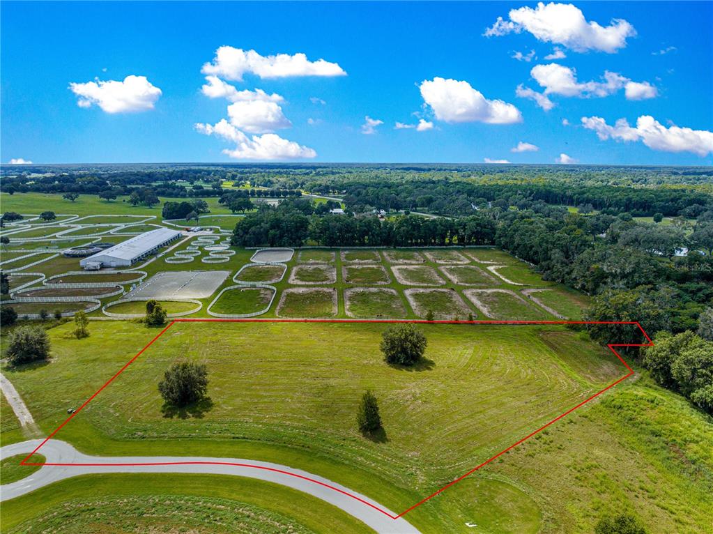 An aerial view shows a large, grassy, undeveloped plot of land outlined in red — TBD SE 8TH AVENUE Lot 306, OCALA, FL