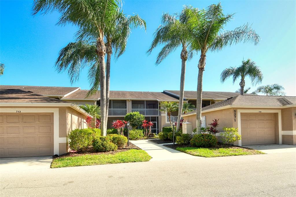 A two-story residential building with two garages, palm trees, and a central walkway — 5271 MAHOGANY RUN AVENUE UNIT 712, SARASOTA, FL