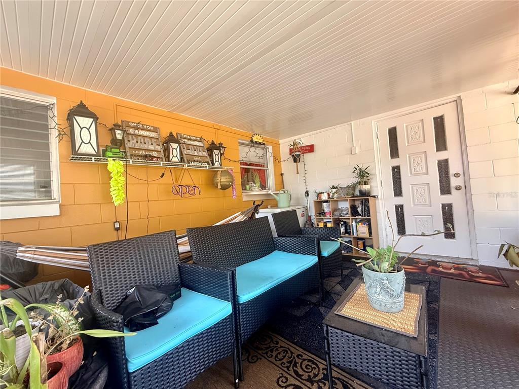 An empty room with orange walls, wood-look flooring, a wood-burning stove, and a white door — 611 RIDGEFIELD AVENUE, OCOEE, FL