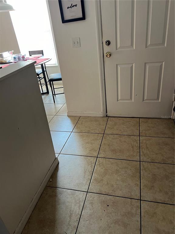 A tiled entryway leads to a dining area with a table and chairs — 625 S DELMONTE COURT, KISSIMMEE, FL