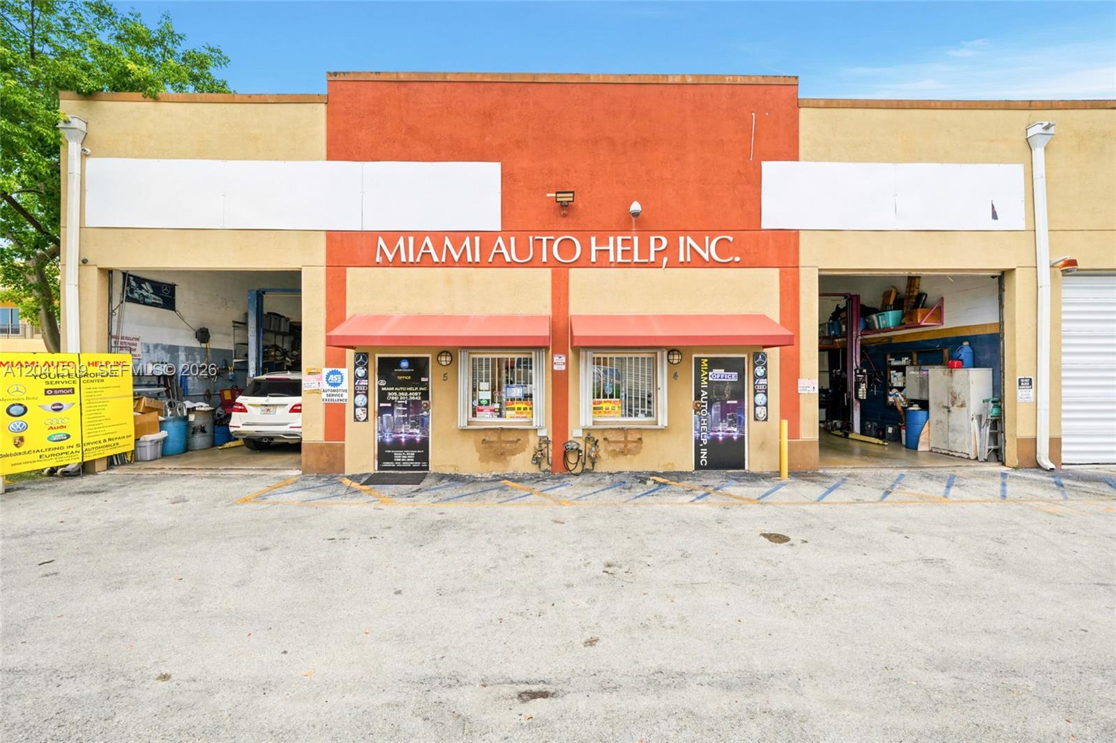 The exterior of a commercial auto repair shop with two open garage bays — 11951 SW 144th Ct # 5, Miami FL 33186, MIAMI, FL