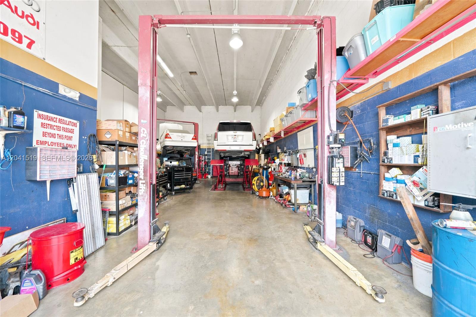 An automotive repair shop features two vehicle lifts, storage shelving, and concrete flooring — 11951 SW 144th Ct # 5, Miami FL 33186, MIAMI, FL