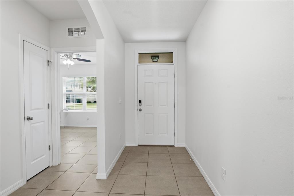 An interior entryway with white walls, tile flooring, and a white front door — 35803 HILLBROOK AVENUE, ZEPHYRHILLS, FL