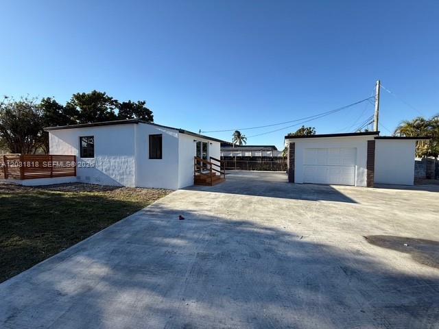 A white house with a detached garage sits on a large concrete driveway — 1800 SW 75th Ave Rd, Miami FL 33155, MIAMI, FL