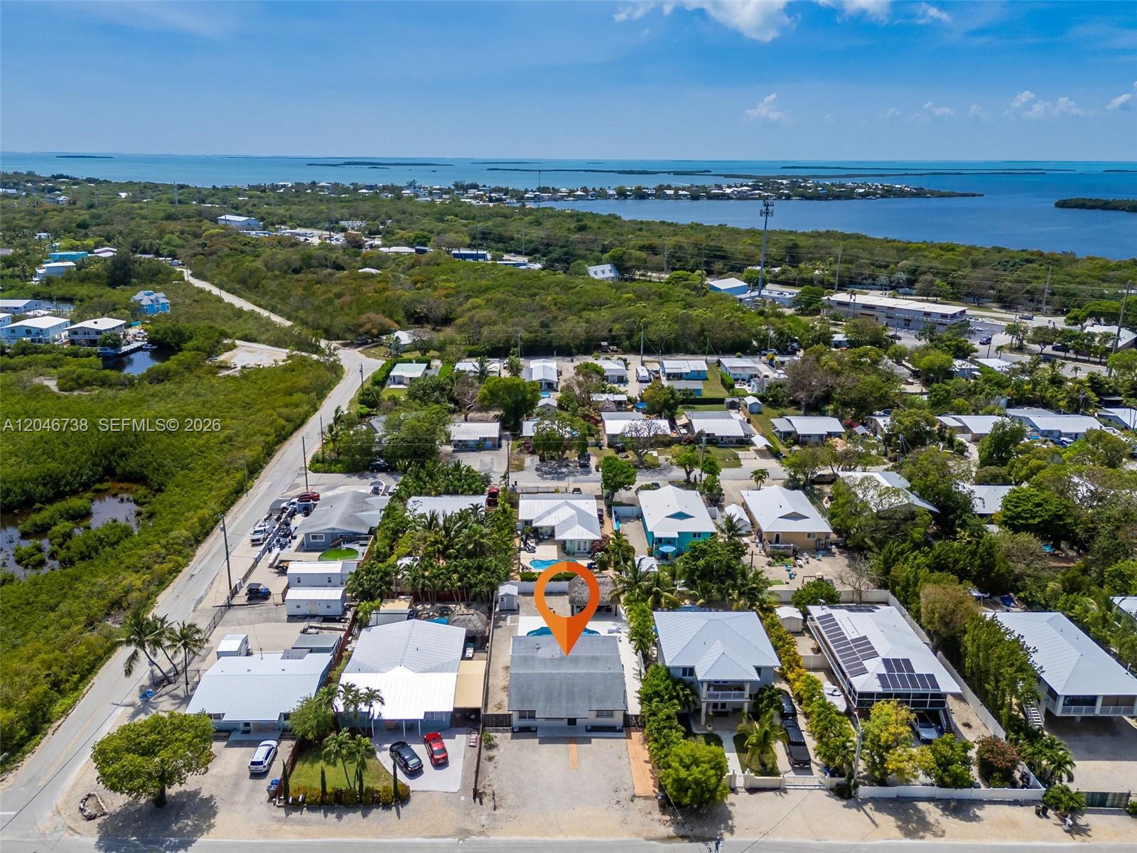 An aerial view shows a residential neighborhood with a highlighted house featuring a pool — 16 Fishermans Trl, Key Largo FL 33037, KEY LARGO, FL