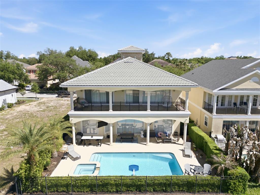 An aerial view of a two-story house with a swimming pool and a fenced backyard — 7390 GATHERING COURT, KISSIMMEE, FL