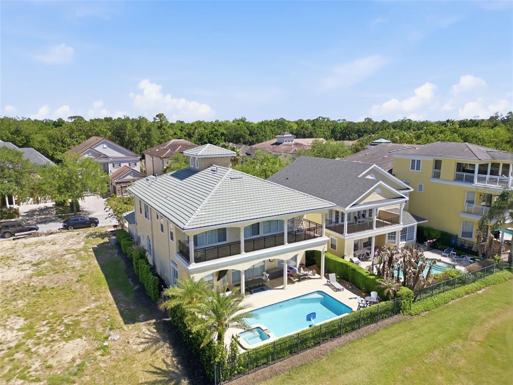 An aerial view shows a two-story house with a swimming pool and a fenced backyard — 7390 GATHERING COURT, KISSIMMEE, FL