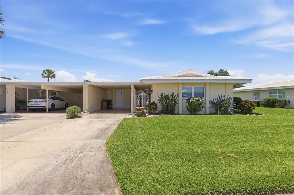 A single-story house with a carport, concrete driveway, and a large front lawn — 3262 BROCKTON LANE UNIT 608, SARASOTA, FL