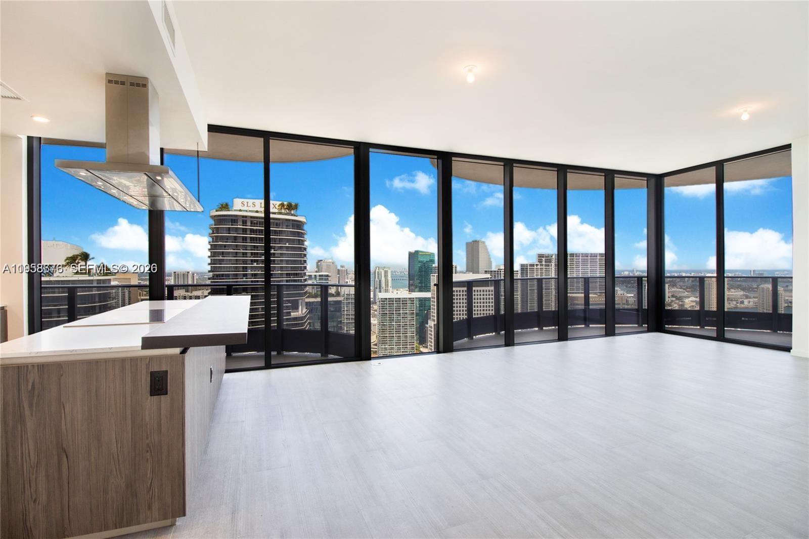 An open-plan kitchen and living area features floor-to-ceiling windows with a city skyline view — 1000 Brickell Plz, Miami FL 33131, MIAMI, FL