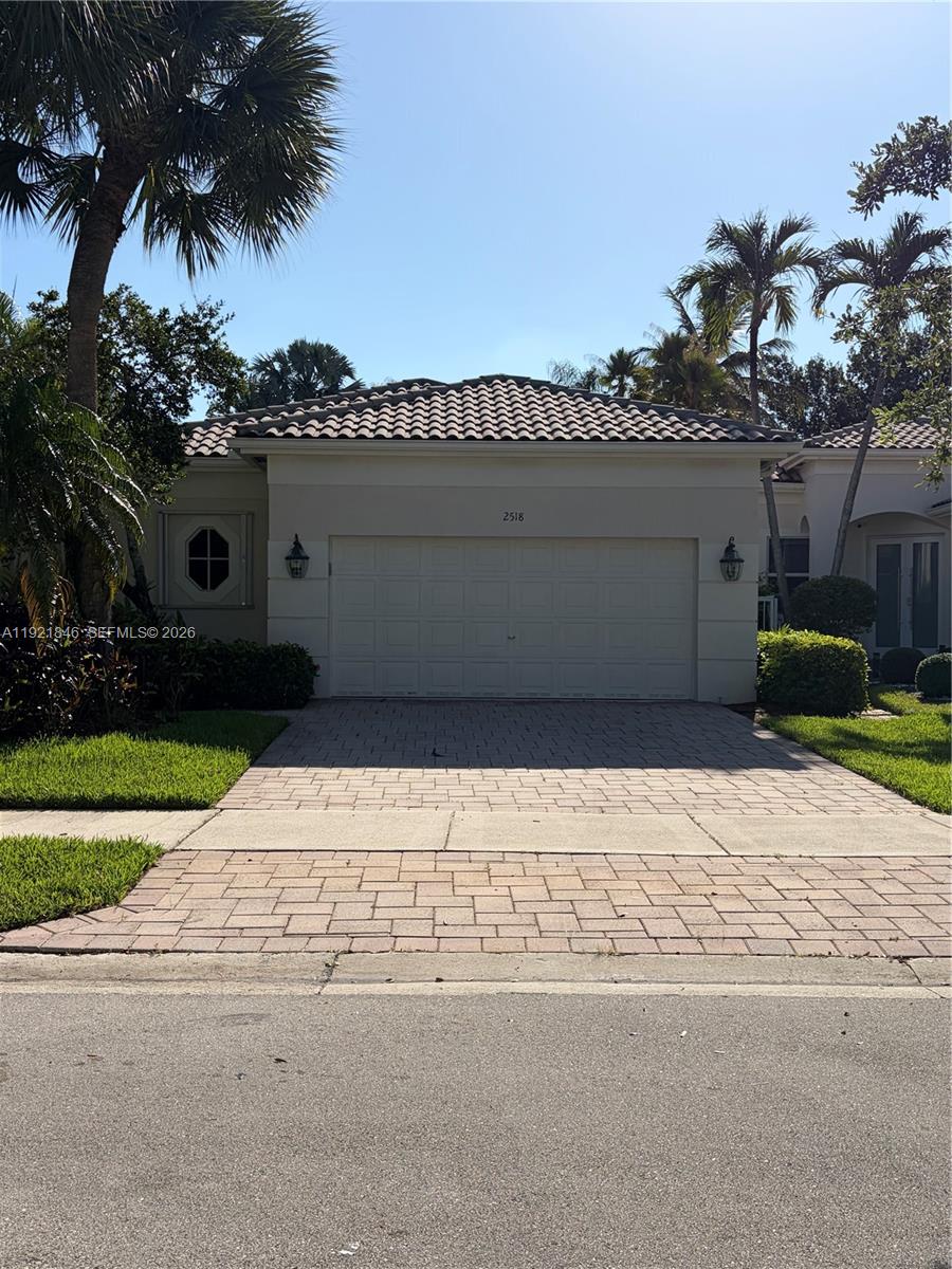 A single-story house with a tiled roof, a two-car garage, and a paved driveway — 2518 Bay Pointe Ct, Weston FL 33327, WESTON, FL