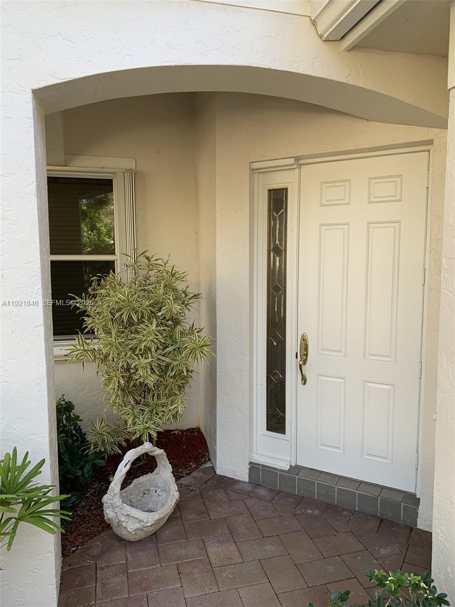 A white front door with a side window sits under an arched entryway — 2518 Bay Pointe Ct, Weston FL 33327, WESTON, FL
