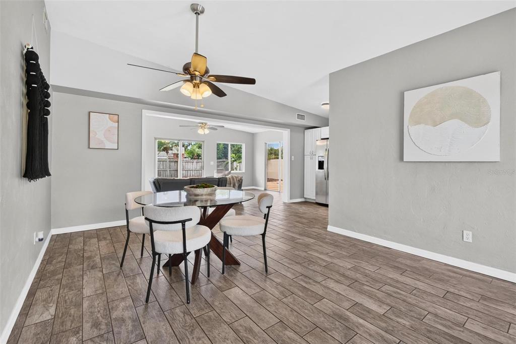 A dining area with a glass table, four chairs, and wood-look tile flooring — 5520 8TH AVENUE N, ST PETERSBURG, FL