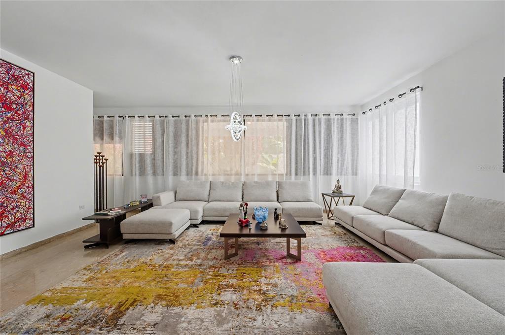 A spacious living room features two large sectionals, a colorful area rug, and a modern chandelier — 2A GIGI STREET, URB.SANTA MARIA, SAN JUAN, PR