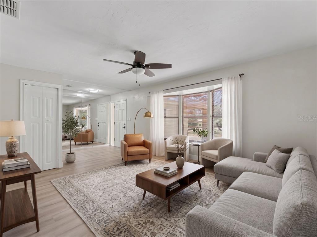 A living room features light wood flooring, a gray sectional sofa, and a bay window — 162 W MASSACHUSETTS STREET, HERNANDO, FL