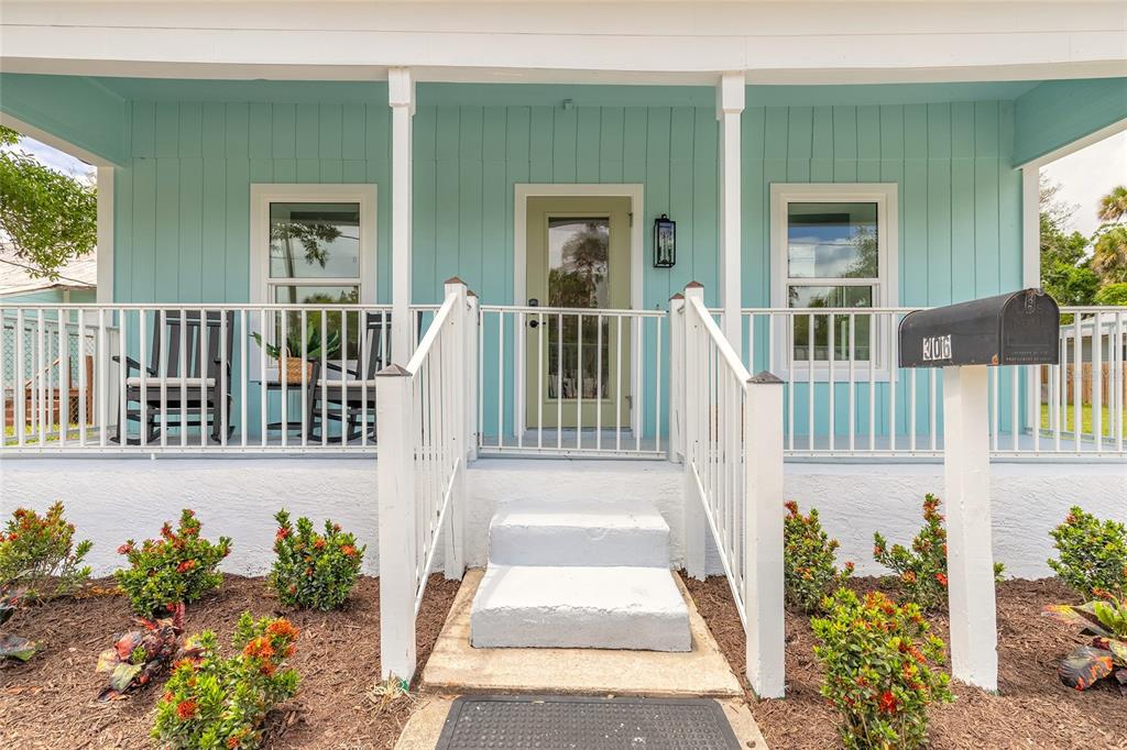 A light blue house features a front porch with white railings and a small staircase — 306 SHELDON STREET, NEW SMYRNA BEACH, FL