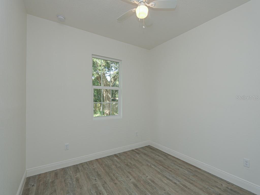 An empty bedroom features white walls, wood-look flooring, a ceiling fan, and a single window — 2831 W LIVINGSTON STREET, ORLANDO, FL