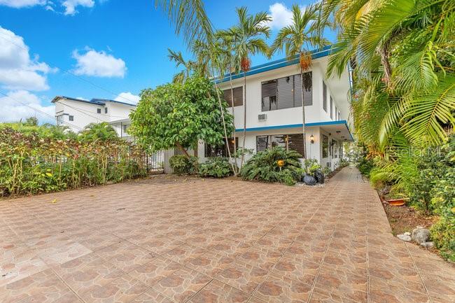 A paved driveway leads to a two-story white building surrounded by palm trees and landscaping — 40 CALLE SURF BO ENSENADA, RINCON, PR
