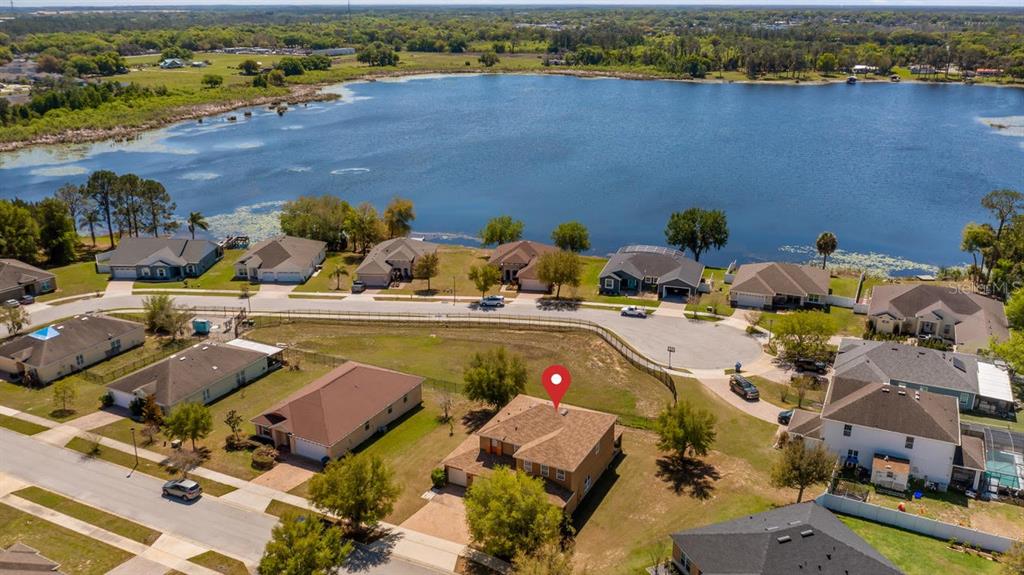 An aerial view shows a residential neighborhood with a house marked by a red pin — 219 BELLA WAY, GROVELAND, FL