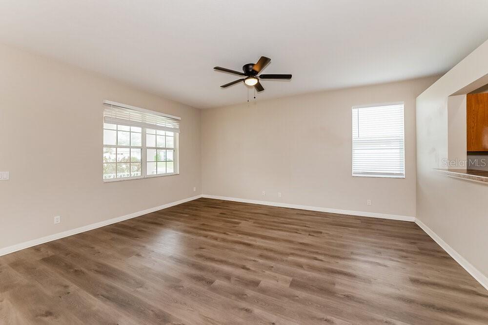 An empty room with light-colored walls, wood-look flooring, a ceiling fan, and two windows — 4246 DAY BRIDGE PLACE, ELLENTON, FL