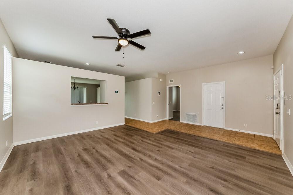 An open-concept living area features wood-look flooring, a ceiling fan, and a tiled entryway — 4246 DAY BRIDGE PLACE, ELLENTON, FL