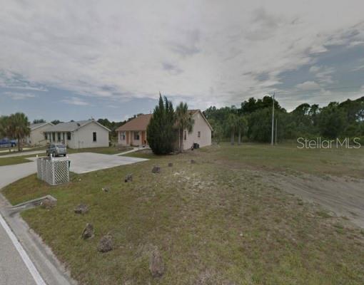 A single-story house sits on a grassy lot next to a neighboring home — 71 BOUNDARY BOULEVARD, ROTONDA WEST, FL