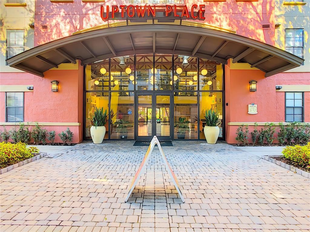 The exterior entrance of an apartment building features a brick walkway and a glass doorway — 911 N ORANGE AVENUE UNIT 441, ORLANDO, FL