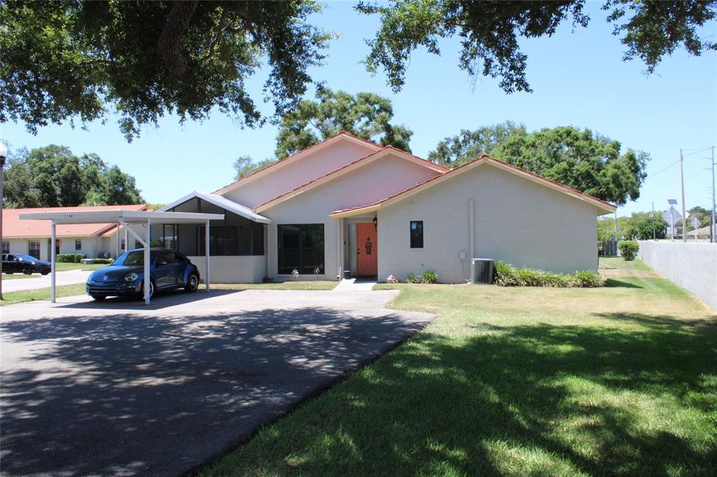 A single-story house with a carport, a red front door, and a paved driveway — 2288 CITRUS COURT, CLEARWATER, FL