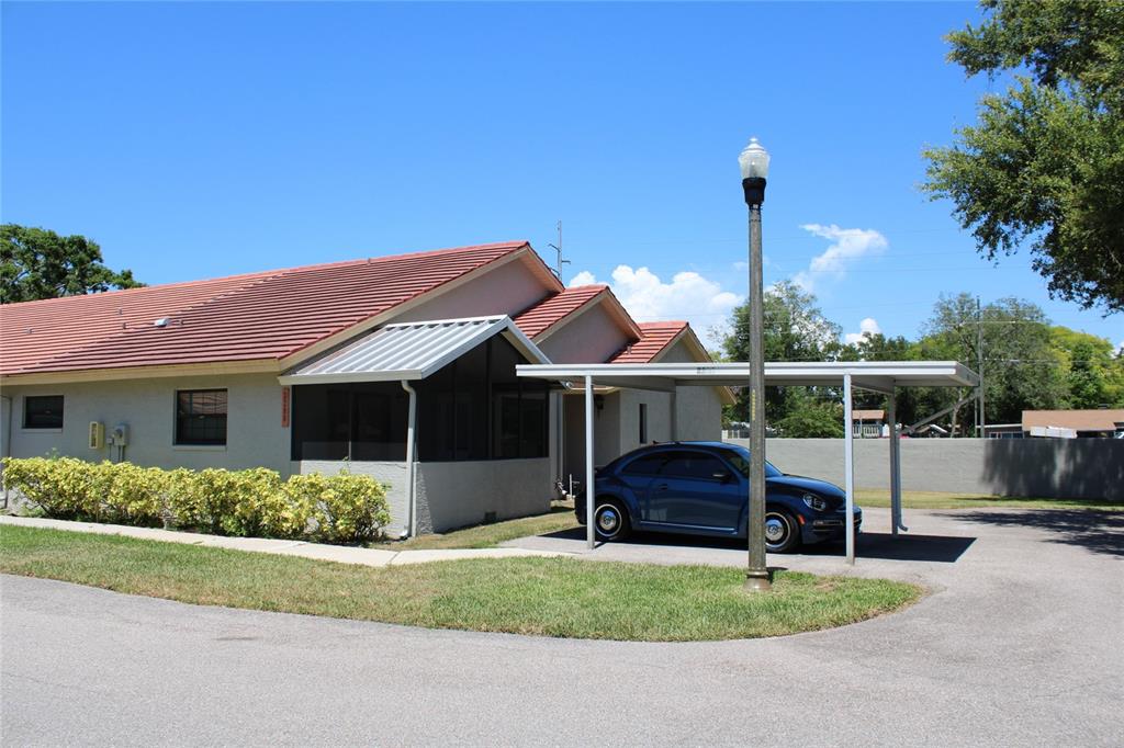 A single-story house with a red tile roof, screened porch, and a metal carport — 2288 CITRUS COURT, CLEARWATER, FL