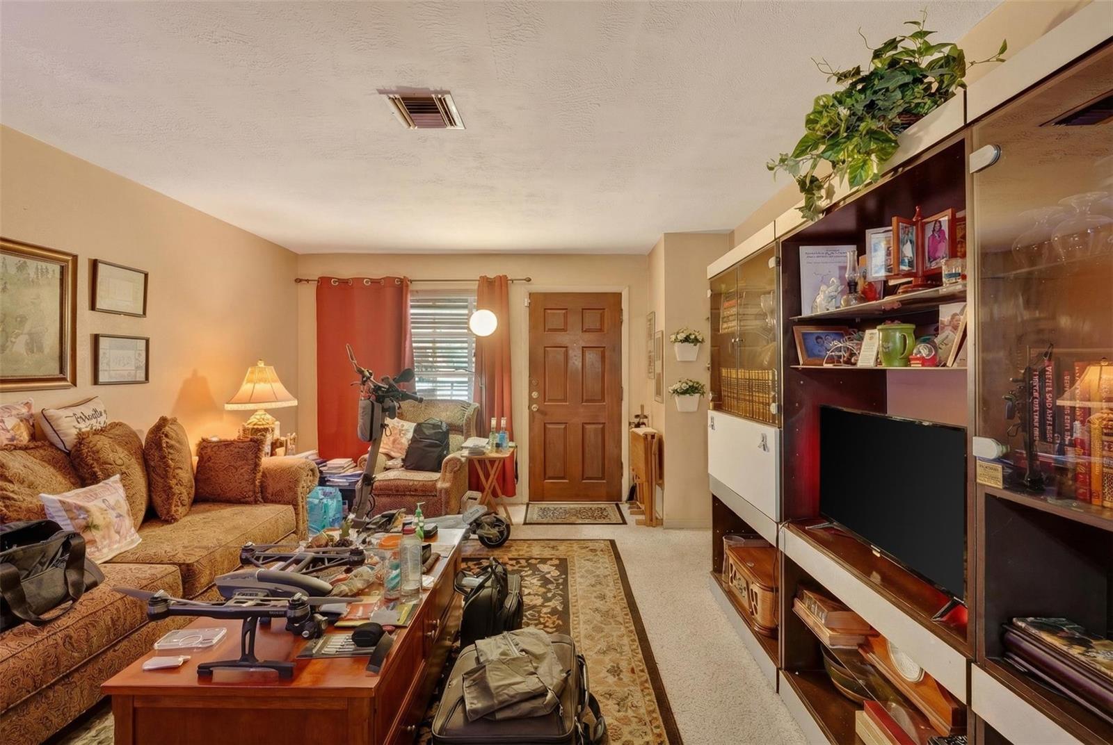 A living room features a brown sofa, a wooden coffee table, and a large wall unit — 154 NW 67th Street, Miami FL 33150, MIAMI, FL