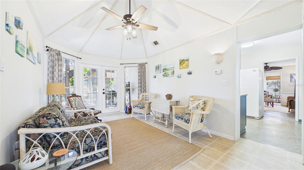 A sunroom features a vaulted ceiling, wicker furniture, tile flooring, and glass French doors — 4319 S CAMERON AVENUE, TAMPA, FL