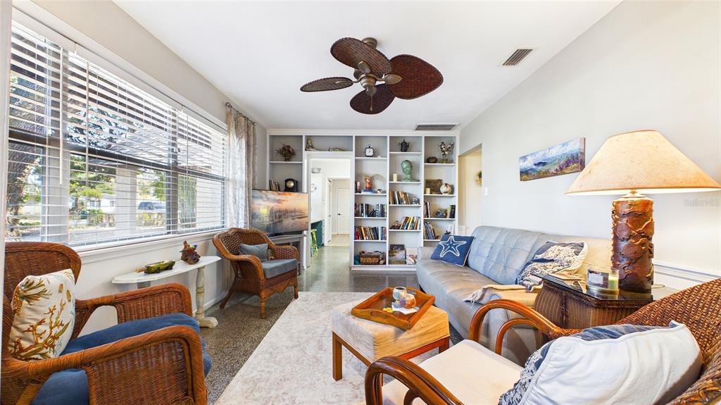 A living room features wicker furniture, a gray sofa, built-in shelving, and a ceiling fan — 4319 S CAMERON AVENUE, TAMPA, FL