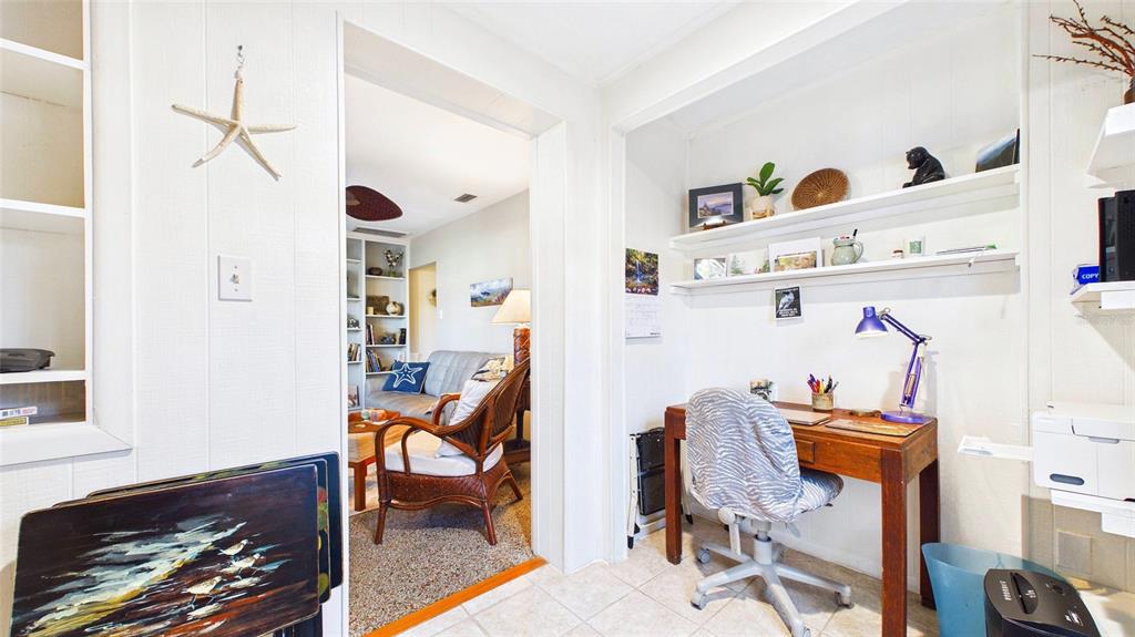 A home office area with a desk and shelves leads into a living room — 4319 S CAMERON AVENUE, TAMPA, FL