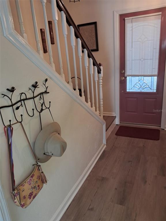An entryway features a staircase with white railings, a coat rack, and a red front door — 1922 S RIVERSIDE DRIVE, EDGEWATER, FL