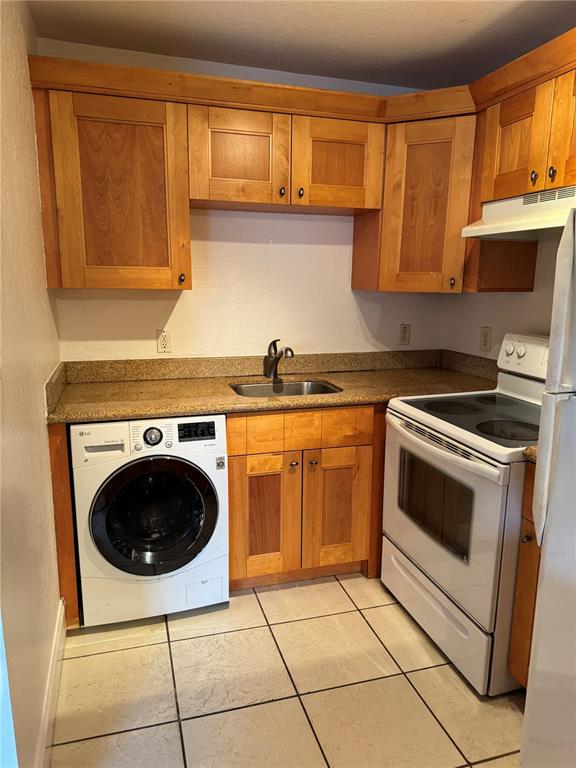 A kitchen featuring wood cabinets, a granite countertop, a sink, a washer, and a stove — 3914 W NEPTUNE STREET UNIT 29, TAMPA, FL