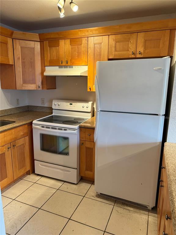 A kitchen features light wood cabinets, a white electric stove, and a white refrigerator — 3914 W NEPTUNE STREET UNIT 29, TAMPA, FL