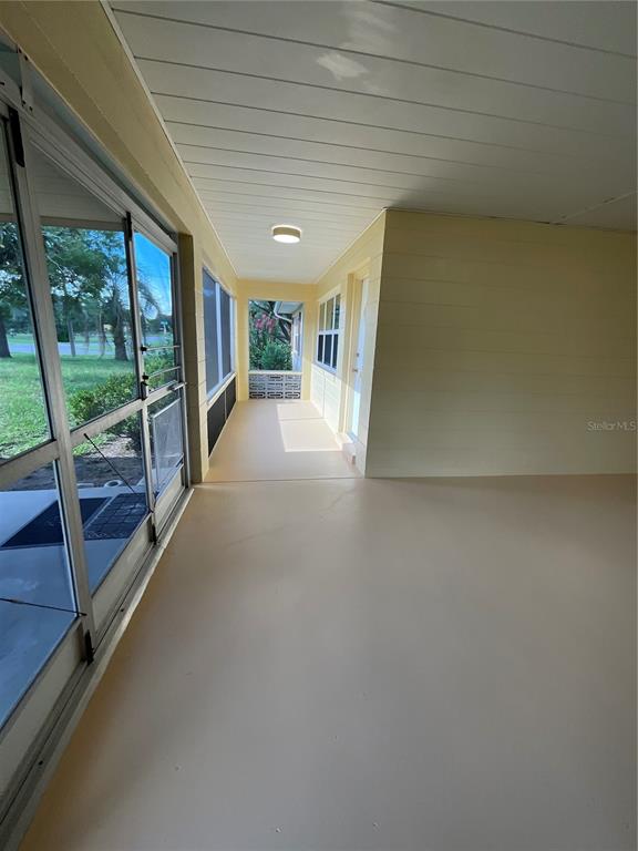 A covered porch with light-colored walls, a painted concrete floor, and screened-in walls — 9359 BAHIA ROAD, OCALA, FL