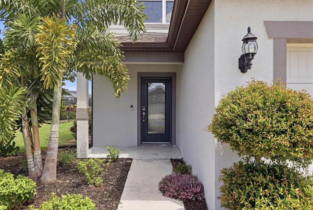 A front entrance features a dark door with a glass panel, a walkway, and landscaping — 9108 ROYAL RIVER CIRCLE, PARRISH, FL