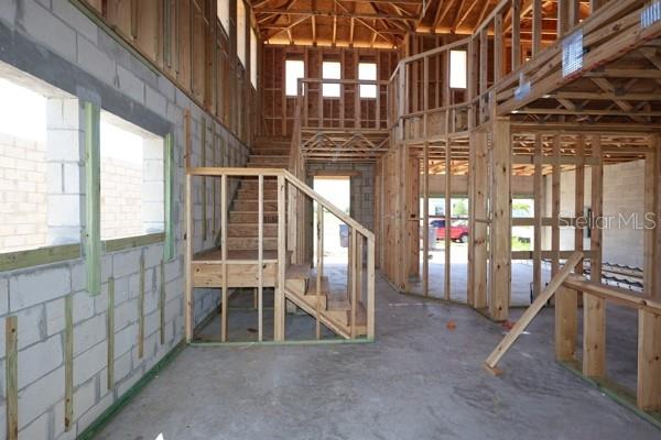 Interior view of a house under construction featuring exposed wood framing and a staircase — 11804 FULL MOON LOOP, PARRISH, FL
