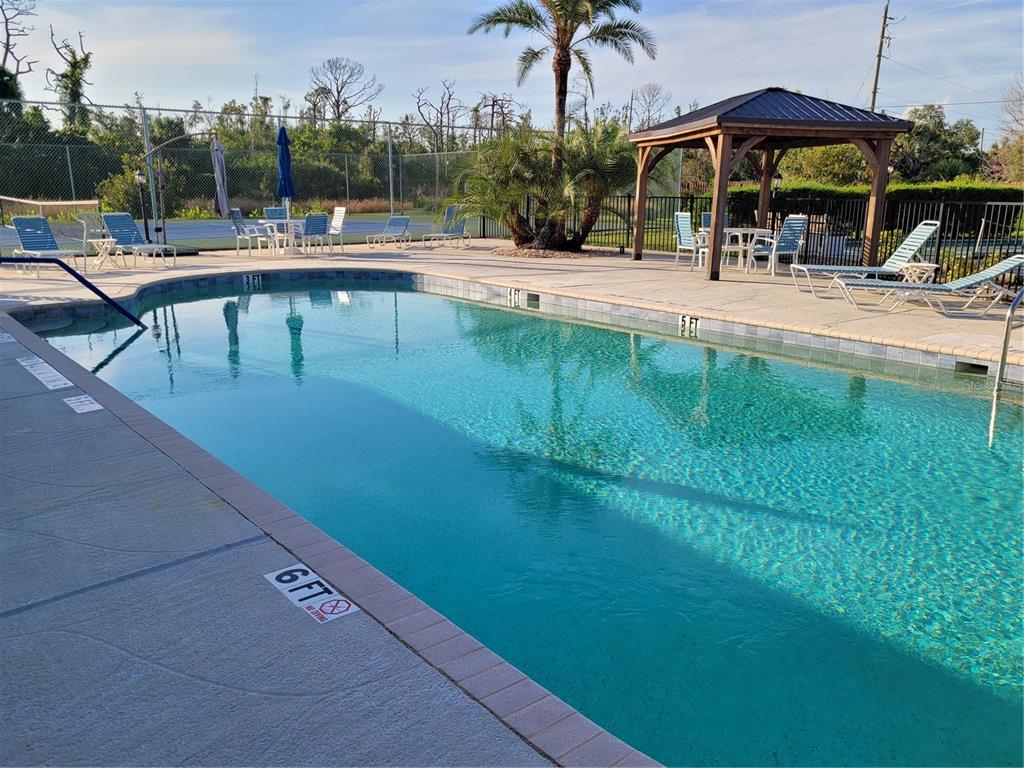 An outdoor swimming pool with lounge chairs and a gazebo on a sunny day — 14277 PALM TERRACE, PORT CHARLOTTE, FL
