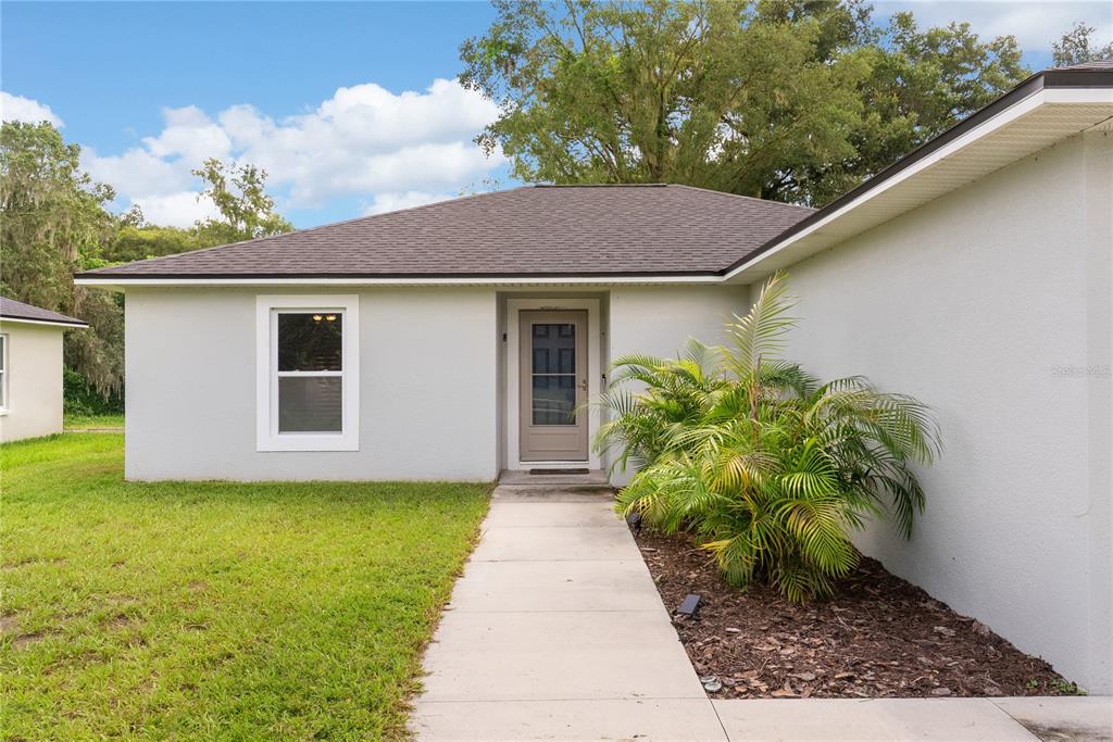 A light-colored single-story house with a concrete walkway leading to the front door — 495 S OAK AVENUE, FORT MEADE, FL