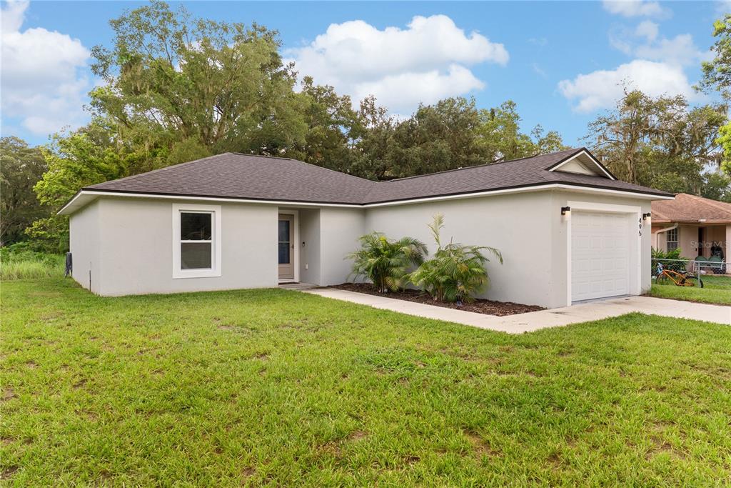 A single-story house with a grey exterior, a dark shingled roof, and a one-car garage — 495 S OAK AVENUE, FORT MEADE, FL