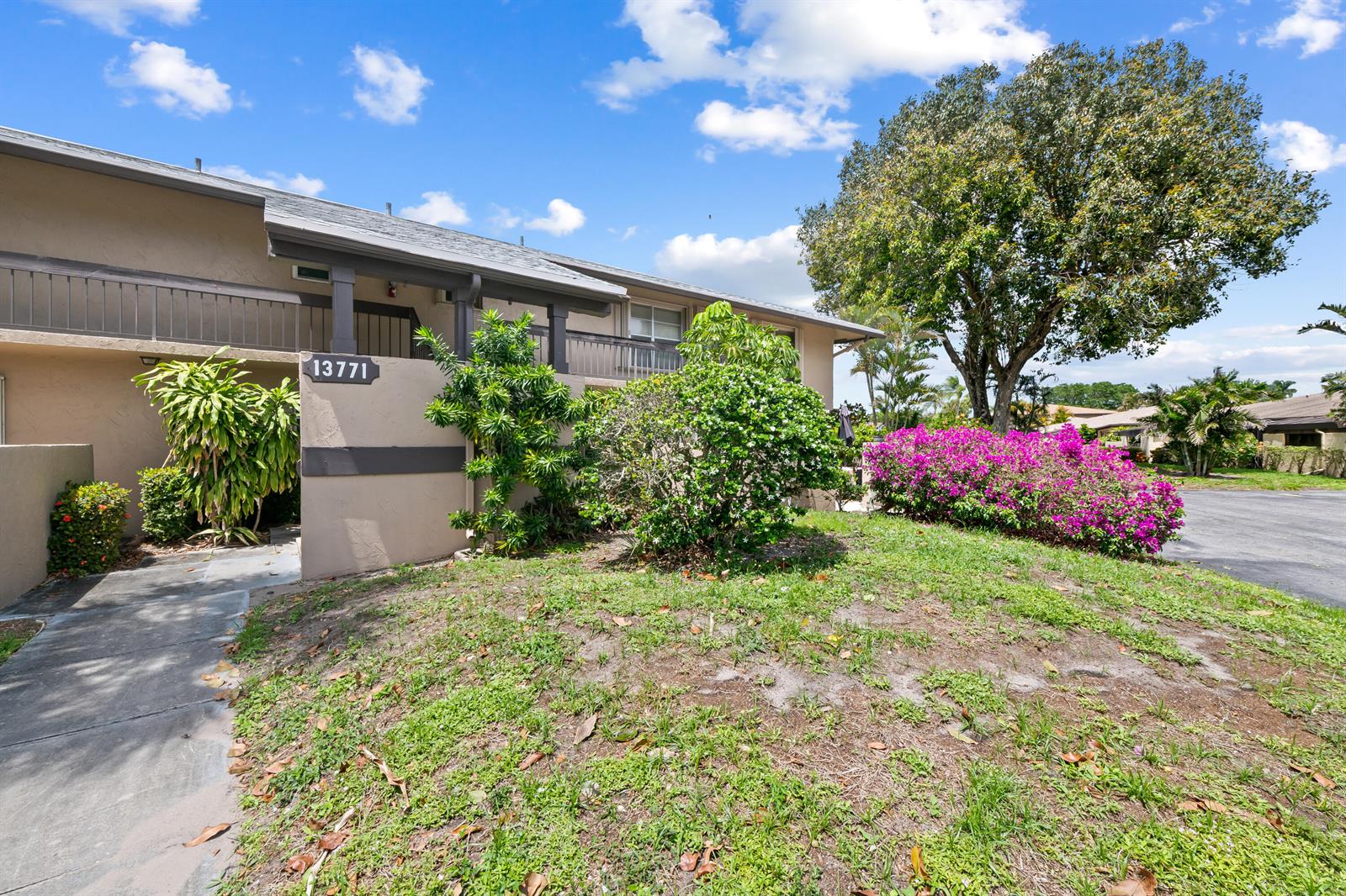 The exterior of a two-story residential building features a walkway, landscaping, and a large tree — 13771 Via Aurora, Delray Beach FL 33484, DELRAY BEACH, FL