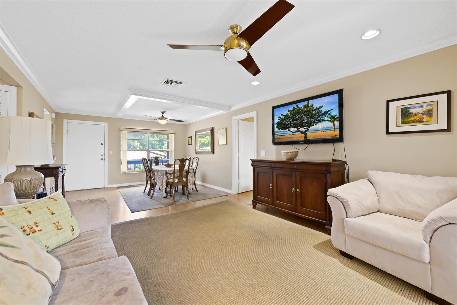A living room and dining area feature beige walls, ceiling fans, and wood furniture — 13771 Via Aurora, Delray Beach FL 33484, DELRAY BEACH, FL