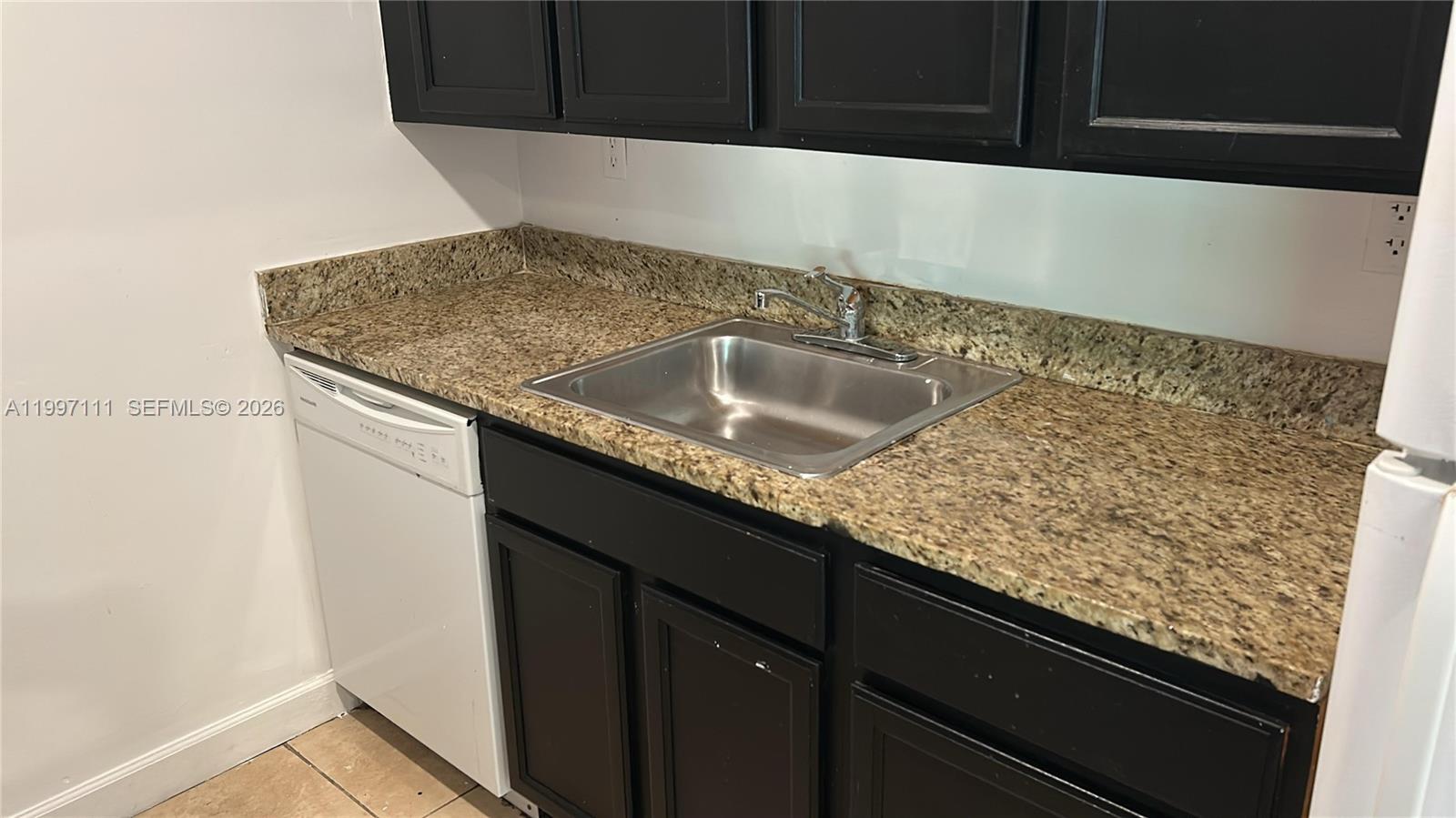 A kitchen features dark cabinets, a granite countertop, a stainless steel sink, and a dishwasher — 1855 NE 121st St # 35, North Miami FL 33181, NORTH MIAMI, FL