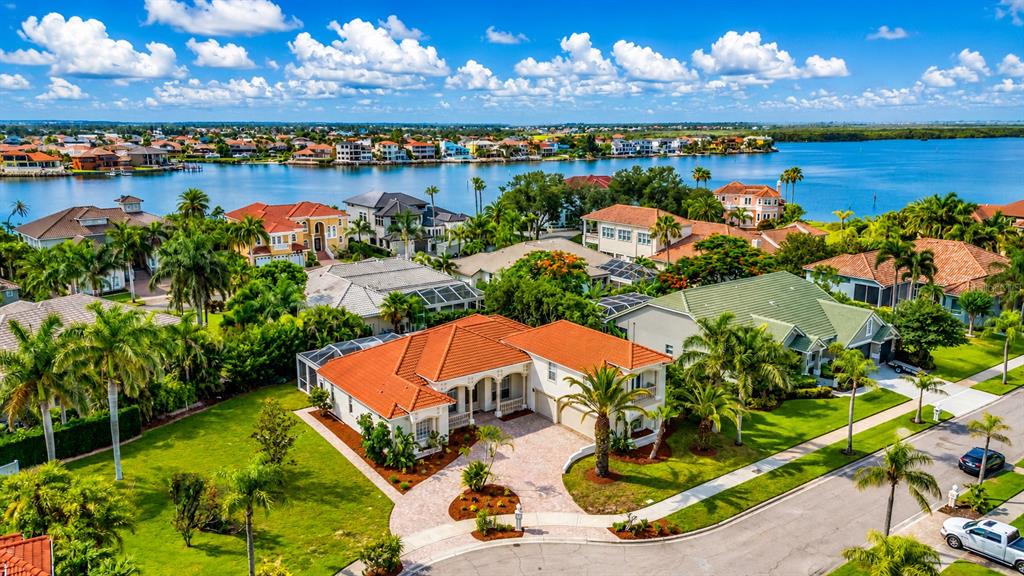 An aerial view shows a residential neighborhood with a large house featuring a red roof — 5909 ZAKI LANE, APOLLO BEACH, FL